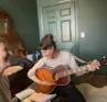 Molly Booker singing while a friend plays guitar