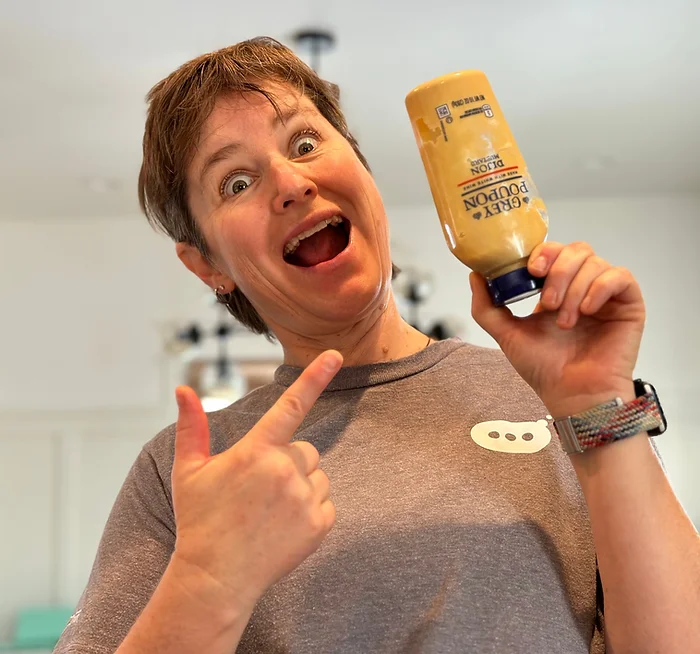 Photo of Molly Booker holding a bottle of Grey Poupon