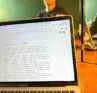 Photo of Molly Booker in the background with a laptop in the foreground
